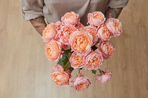 Woman with a bouquet of pink media roses, top view. Mother's Day, Valentine's Day