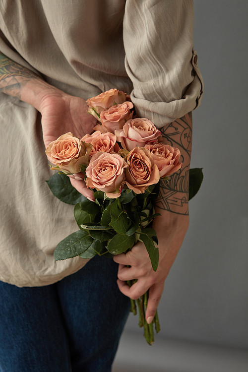 A fragrant bouquet of beige roses cappuccino girl holding in her hand behind her back. Mother's Day,