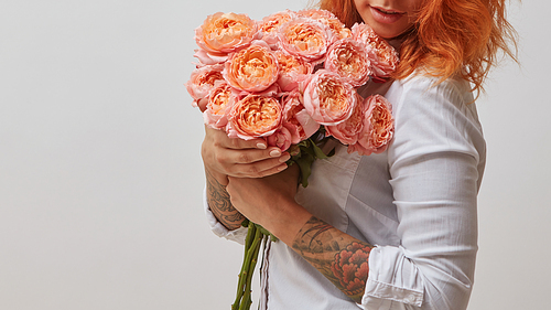 red-haired girl with a tattoo on her arm holding a bouquet of pink roses, valentine's day, mother's day