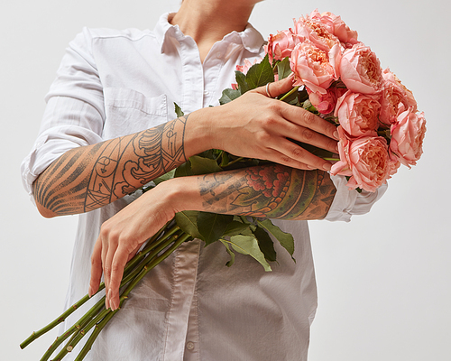 Happy girl with a tattoo on her hands, holding a bouquet of pink media roses, mother's day, valentine's day