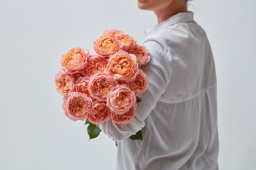 A very beautiful bouquet of pink roses is held by a woman. the best gift for a girl in Valentine's Day.