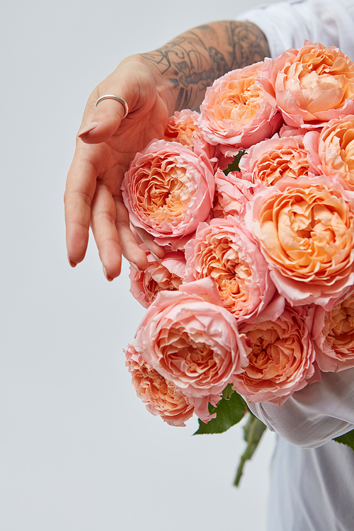 A bouquet of pink media roses, a girl holding a beautiful bouquet in her hands. Mother's day concept, holiday