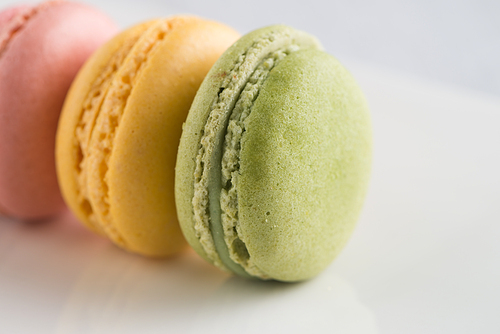 Closeup detail of macarons on a white plate.