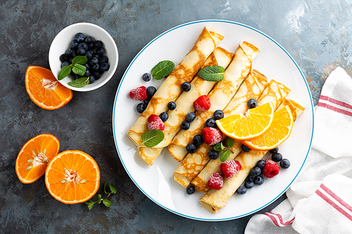 sweet crepes wrapped with fresh berries, crepes with blueberry and raspberry on breakfast, top view