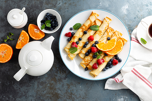 sweet crepes wrapped with fresh berries, crepes with blueberry and raspberry on breakfast, top view