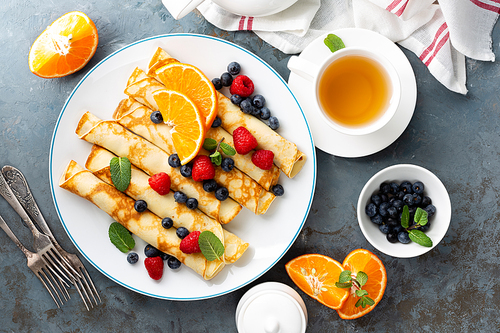 sweet crepe wrapped with fresh berries, crepes with blueberry and raspberry on breakfast, top view