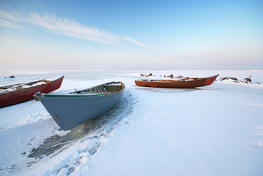Boat on ice. Winter landscape composition.