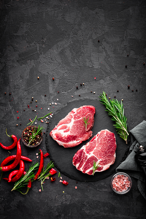 raw pork meat. fresh steaks on slate board on  background. top view