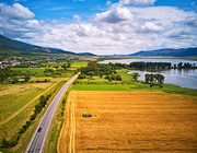 Summer landscape with fields, meadows, lake and mountains. Road on the lakeside. Aerial view of Storage reservoir/lake Hrhovske, Rybniky