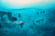 aerial view of the fishing boat in clear blue water at  in summer. top view from the air of boat, sandy beach. indian ocean in zanzibar, africa. landscape with motorboat and clear sea. travel