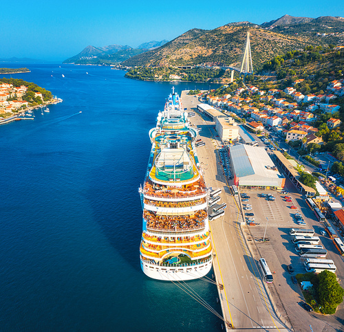 Aerial view of cruise ship in port at sunset in Dubrovnik, Croatia. Beautiful ships, boats and yachts. Landscape with harbor, city, mountains, blue sea. Luxury cruise. Top view of floating liner