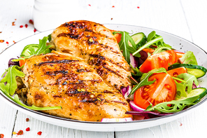 Grilled chicken breast. Fried chicken fillet and fresh vegetable salad of tomatoes, cucumbers and arugula leaves. Chicken meat salad. Healthy food. White background
