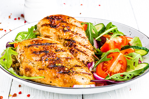 grilled chicken breast. fried chicken fillet and fresh  salad of tomatoes, cucumbers and arugula leaves. chicken meat salad. healthy food. white background