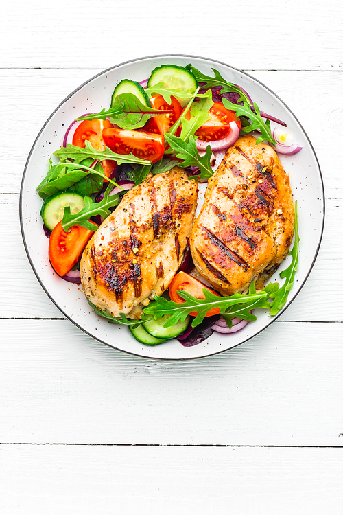 grilled chicken breast. fried chicken fillet and fresh  salad of tomatoes, cucumbers and arugula leaves. chicken meat salad. healthy food. flat lay. top view. white background