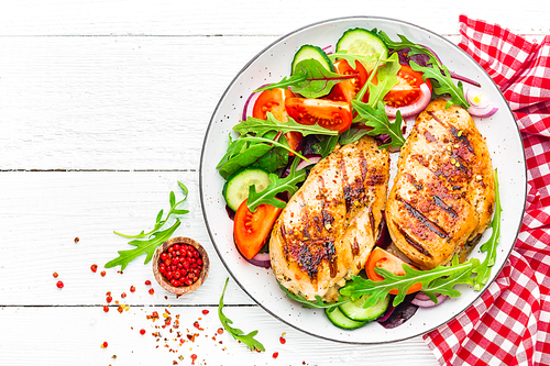 grilled chicken breast. fried chicken fillet and fresh  salad of tomatoes, cucumbers and arugula leaves. chicken meat salad. healthy food. flat lay. top view. white background
