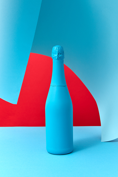 Creative blue painted holiday wine bottle mock up on a duotone wavy background with soft shadows, copy space. Minimalism concept.