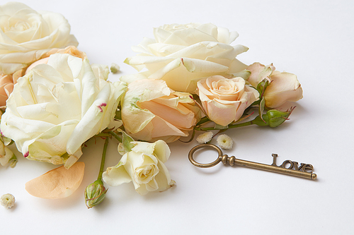 key and bouquet of roses on a white background