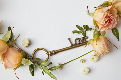 frame with roses and a key on a white background with space for text