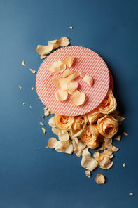 Waffle cake with buds and rose petals on a dark background