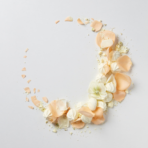 delicate round vintage frame with beige roses and air meringue isolated on white, flat lay
