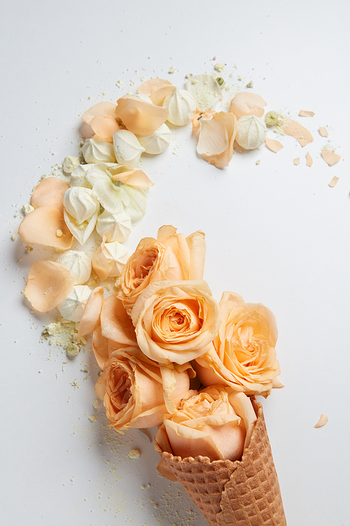 Valentine's Day ice cream with orange flowers, petals and white zephyrs over white background. Copy space may be used for your ideas, emotions and concepts.