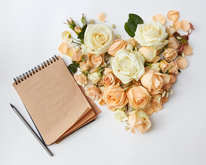 heart of roses flower and notepad book on white background , flat lay