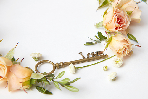 Key with rose petals as a symbol of love isolated on white