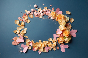 Circle of waffles and roses as decoration of navy blue background. Many hearts demonstrating about Valentine's Day.