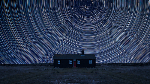 Digital composite image of star trails around Polaris with Stunning vibrant landscape of Remote desolate isolated house
