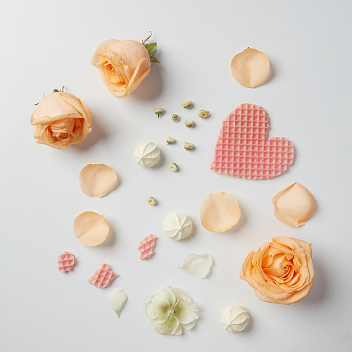 Closeup of roses and waffles represented on white background. Waffles and roses with many hearts used for decoration of background.