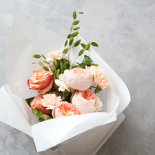 wedding bouquet of peach roses on a concrete background