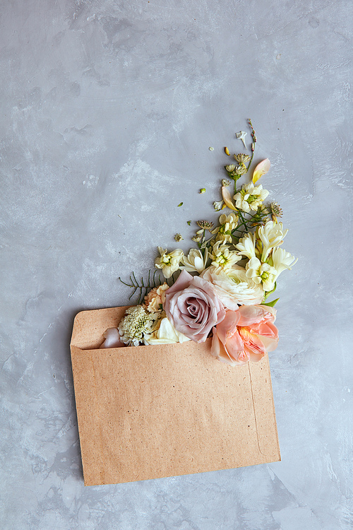 flowers in envelope on the gray stone background.  for you. spring background. flat lay.