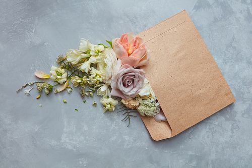 Romantic envelope with flowers on the stone gray background. flat lay