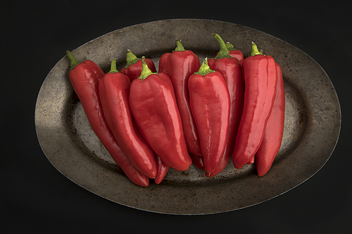 An overview of spicy red peppers stacked on a platter.