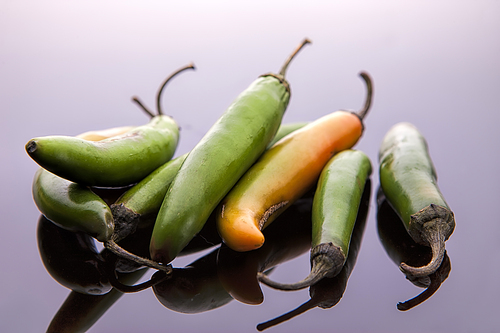 A close up studio image of a bunch of jalapeno peppers.