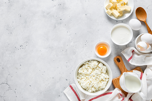 Pitcher with milk, egg, cottage cheese, butter and yogurt on kitchen table. Ingredients for cooking on kitchen table. Culinary background. Top view. Flat lay