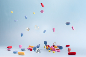 Pile of colorful medical pills on blue background, top view