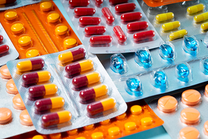 Pile of medical pills and capsules close up macro background. Pills in plastic package. Concept of healthcare and medicine.