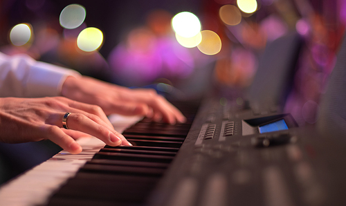 Fingers keyboardist on the background of the guitarist.