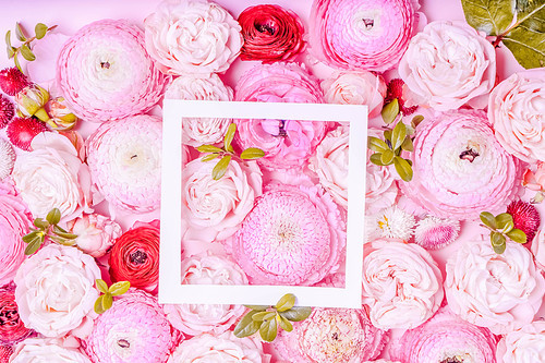 Flowers composition. Frame made of roses and ranunculus flowers with leaves on pink background. Flat lay, top view, toned