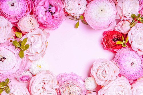 Flowers composition. Frame wreath made of roses and ranunculus flowers on pink background. Flat lay, top view, toned
