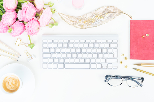 Flat lay home office workspace - modern keyboard with cup of coffee and ranunculus flowers