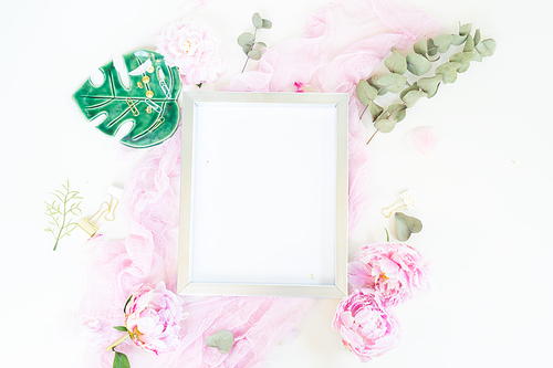 Creative wedding composition with metalic photo frame mock up, pink blanket, flowers on white desk background. Flat lay, top view stylish art concept.