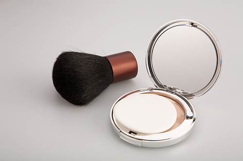 Collapsible mirror and brush for blush on a white background