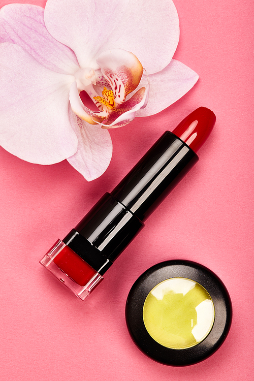 Fashionable Women's Cosmetics and Accessories. Falt Lay. Red Lipstick and Yellow Eyeshadow. Beautiful Orchid Flower. Make Up Cosmetic items Top View