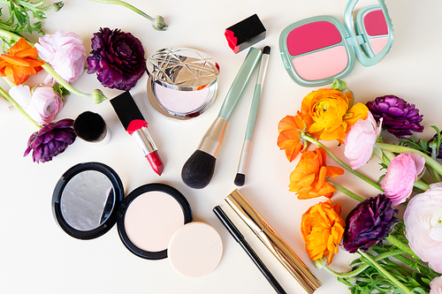 beauty products with flowers, top view on pink
