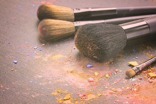 set of  professional make up brushes on black background, retro toned