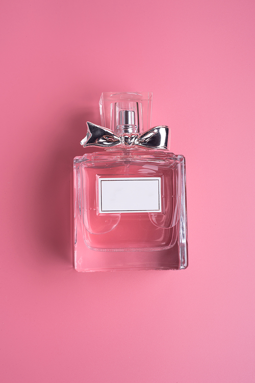 perfume bottle  on pink  background. flat lay