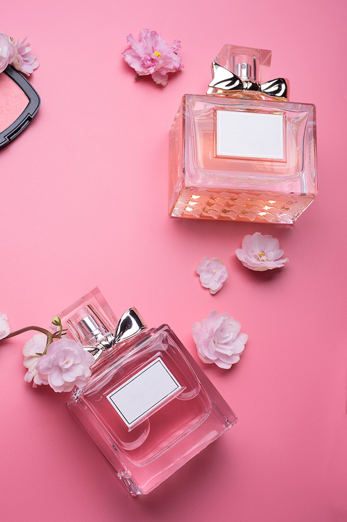perfume bottles  around flowers on gradient   pink   background.