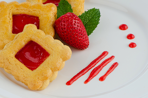 Strawberry cookies with strawberry on plate.